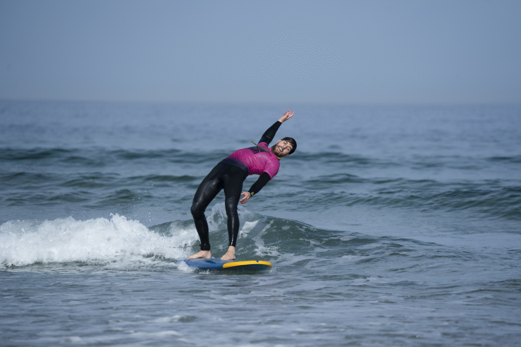 A student smiling while accepting his faith falling to the water on a surflesson in Pantin